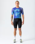 Person wearing a blue and black cycling outfit on a white background