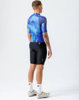 Person wearing a blue and black cycling outfit on a white background