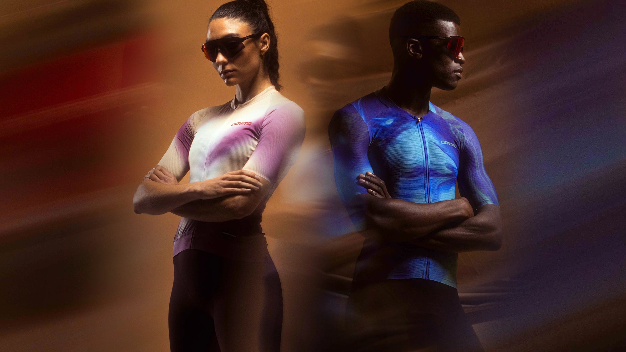 Two people wearing cycling jerseys with glowing colors against a blurred background